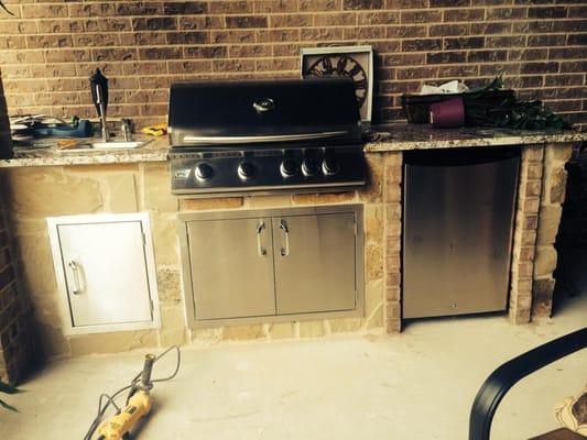 Outdoor kitchen- 32"grill with double door, sink with single door, and fridge. Mix of stone and brick for frame.