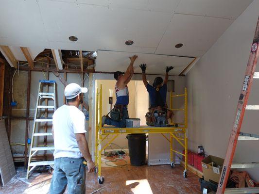 Installing drywall to the newly vaulted ceiling.