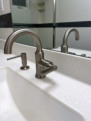 Solid surface sheet is heated to create the curve and seamless finish from the edge of sink to the bottom of mirror.