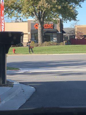 Worker holding $19.99 oil change sign