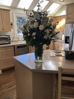 Fresh flower arrangement in white with hints of blue.