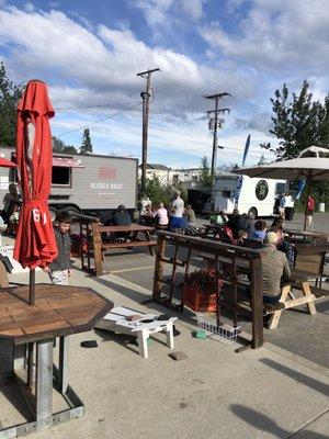 Outdoor patio with Reuben Haus food truck parked in the summer