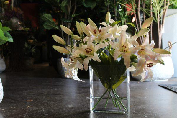 Fake flowers arranged in glass container with "water." aka. resin.