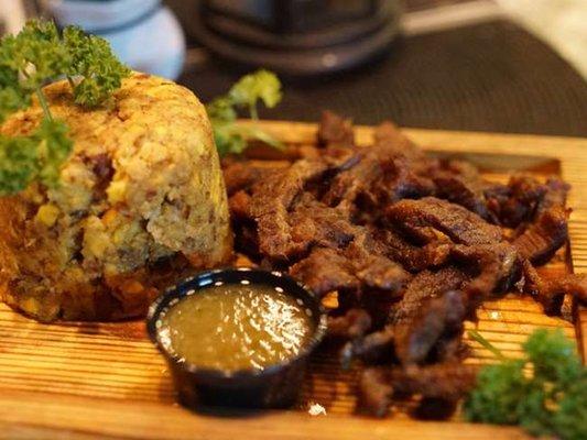 Mofongo con Churrasco: Garlic green plantain mash topped with skirt steak & choice of garlic cilantro aioli, pico de gallo, or green sauce