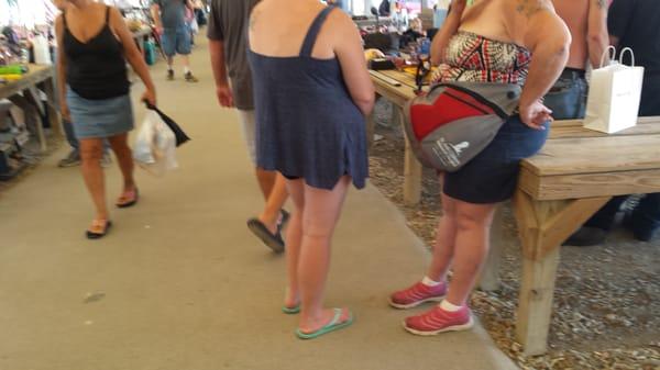 Yes, the lady on the right is using a single shoulder backpack as a fanny pack!!!  The flea markets got people of Walmart beat!