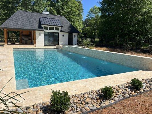 Concrete pool, Ivory Travertine decking and copping, feature wall with waterfalls