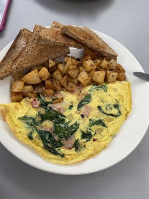 Custom omelette spinach, ham and tomato. It comes with home fries and toast.