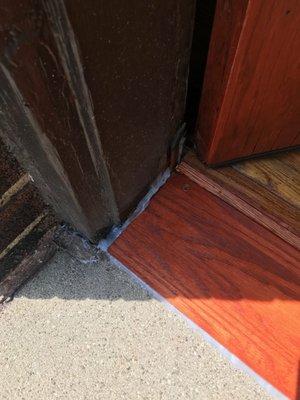 Sloppy caulk around threshold.