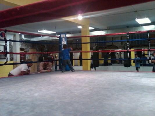 Two fathers catch up on the day's events while an aspiring boxer checks out the ring