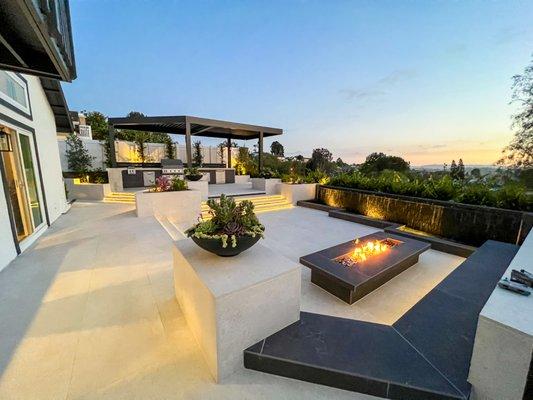 Backyard hardscapes design. Sunken patio with Concrete bench, firepit, and wall water fall fountain.