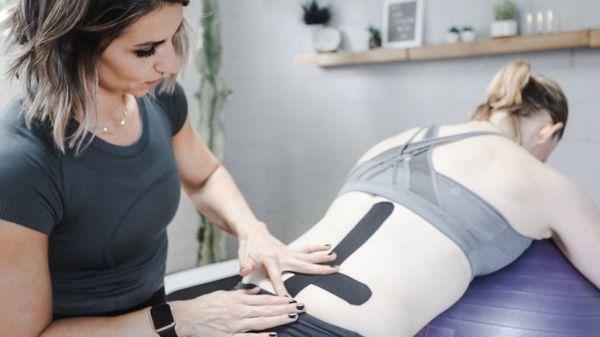 Lindsay applying kinesiotape to help with low back pain