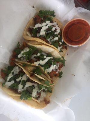 Tacos de pastor (pork tacos) with onion cilantro and sour cream! Yummmm