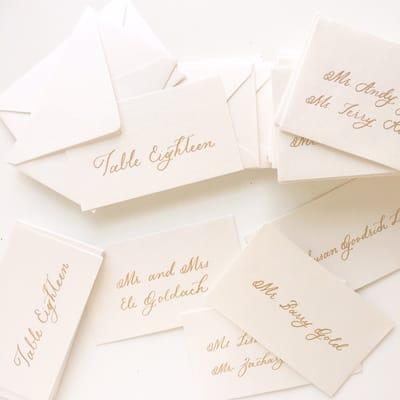 Gold ink calligraphy on mini envelopes for escort cards