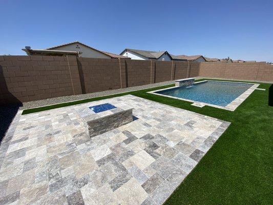 Firepit, travertine paver patio and border, faux grass with rock border.