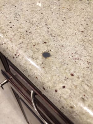 One of the many epoxy filled holes (they used a dark color on a cashmere white granite)