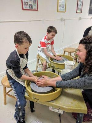 The boys getting a lesson on how to use the potters wheel and brushing on the glaze after their bowls we're finished.