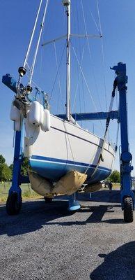 52' Beneteau Oceanis with a 7' 9" draft in the slings of our 60 Ton Travelift getting ready for a late fall launch.