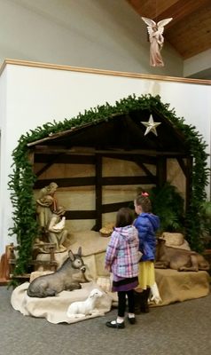 Children looking upon the church nativity scene.