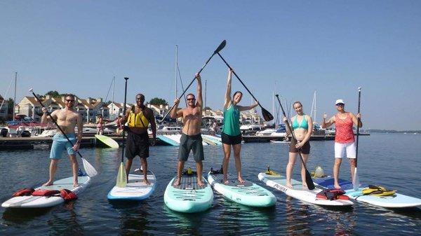 Amber, Troy, and friends taking a SUP Yoga class when Lake Yoga Tribe was just an inkling of an idea