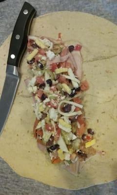 Mediterranean Wrap. Ham, pepperoni, Kalamata & Spanish olives, eggs, tomatoes, feta & mozzarella cheese w/homemade Greek dressing