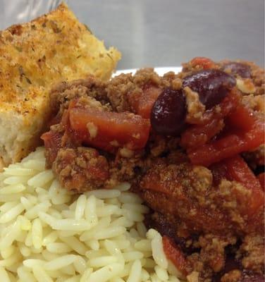 Extreme closeup of chili and rice with garlic-chili bread.