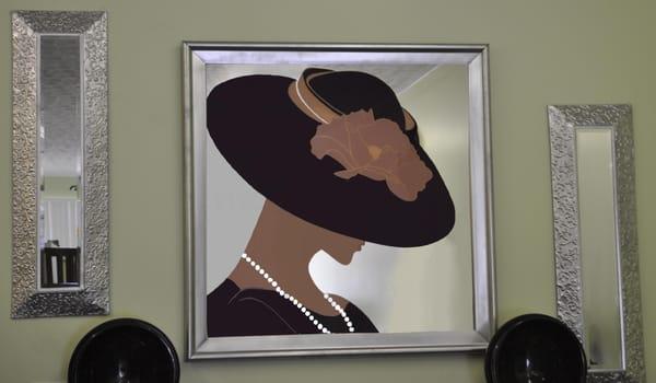 Mirror of a Lady wearing a black hat and pearls.