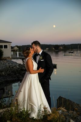 Wedding photography photographer York Kittery Point Maine bride and groom kissing while standing with moon and sunset reflecting on ocean