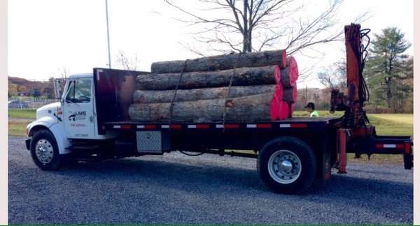 Knuckleboom log loader for hauling away trunk wood.