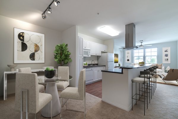 Kitchen with breakfast bar between staged living and dining room.