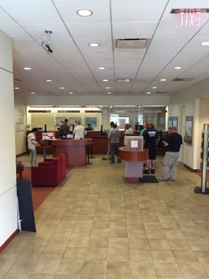 One teller and over 10 people in line. The manager is just hanging around while another employee just stands there and watches.