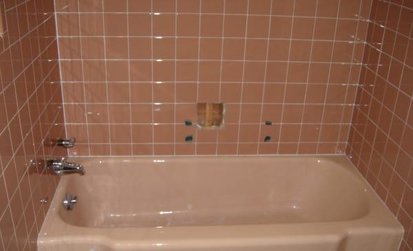 Out dated peach color tub and tile surround