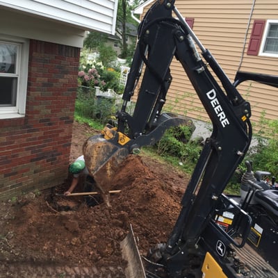 Excavation at corner of house for foundation repair