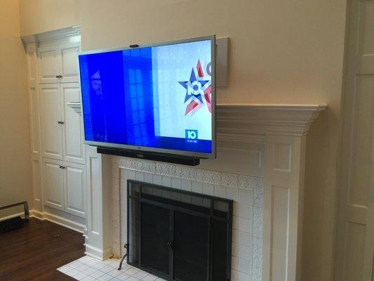 TV mounted over fireplace utilizing a mantel mount that drops the TV down 24"