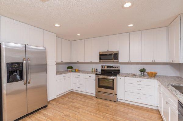 Newly reconfigured kitchen with removing the old soffits and an old wall, installed new cabinets, countertops, flooring, and new paint.