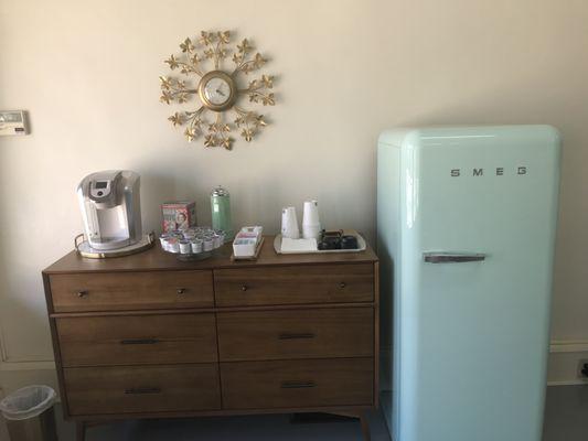 Cute coffee station, fridge filled with soda and water.