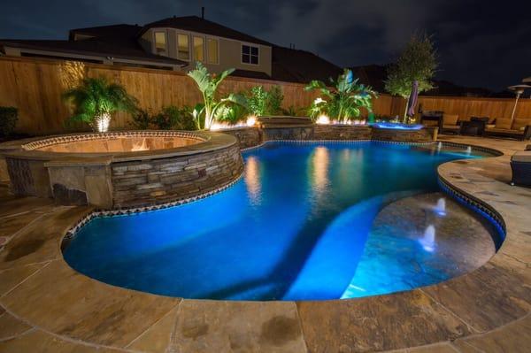 Custom flagstone pool and spa, sunken fire pit, fire trough, grotto, pebble finish.