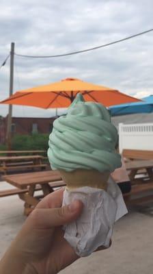 Pistachio soft serve in a cake cone