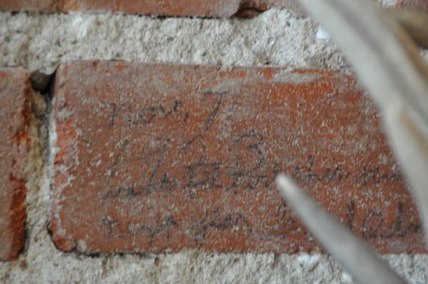 An old brick inside the store that contains a 11/7/1923 date