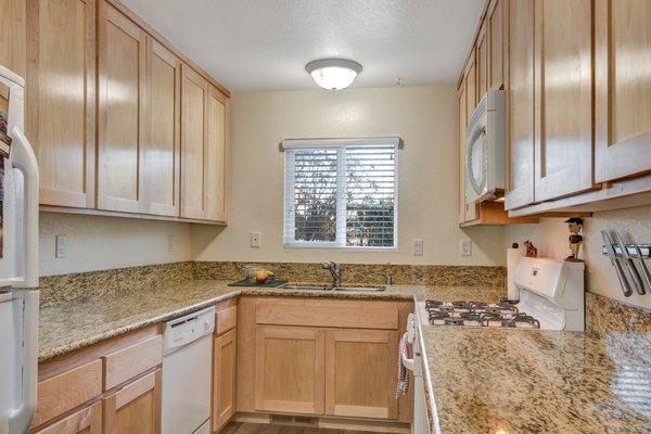 Custom maple cabinetry and granite counters in kitchen and bathrooms