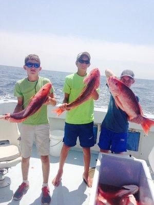 Captain Brandon youngest son (pictured in center) shows his friends how to catch Red Snapper.