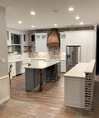 Leathered White Ice granite was installed on the island, and Carrera White Quartz on the outer countertops.