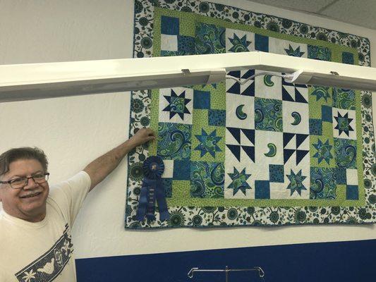 Tuesday, April 9, 2019: inside: Paul showing blue ribbon quilt.