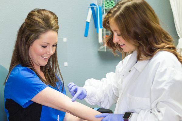 Phlebotomy students preparing for a blood draw.