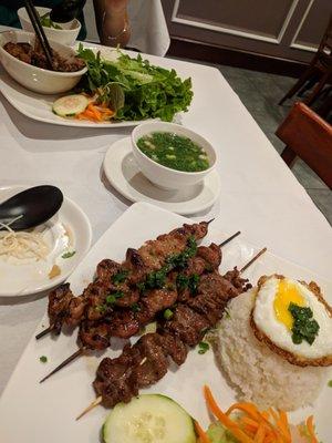 Pork skewers with fried egg and soup.