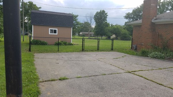 Black vinyl chain link fence with ~10' gate.