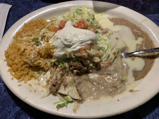 My Burrito Real with rice and refried beans... covered in queso blanco and topped with lettuce, tomato and sour cream