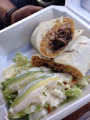 Pork burrito with a side of avocado salad