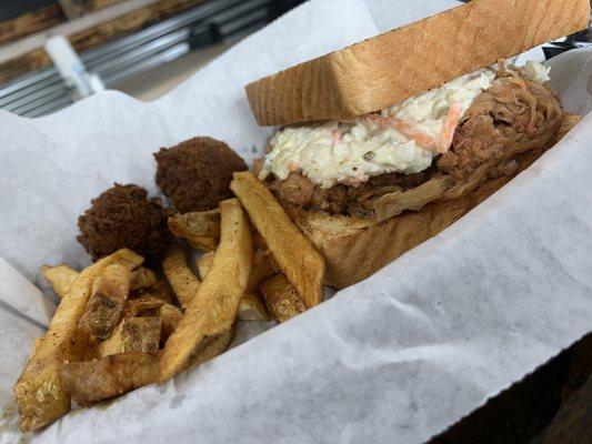 BBQ sandwich with slaw fries and hush puppies.