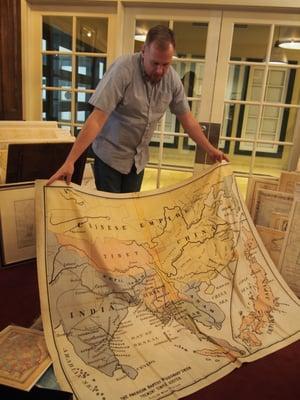 The owner sharing an antique missionary map made of material for ease of travel.