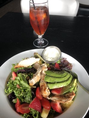 Delicious chicken, avocado, strawberry and roasted sweet pecan salad and ice tea.